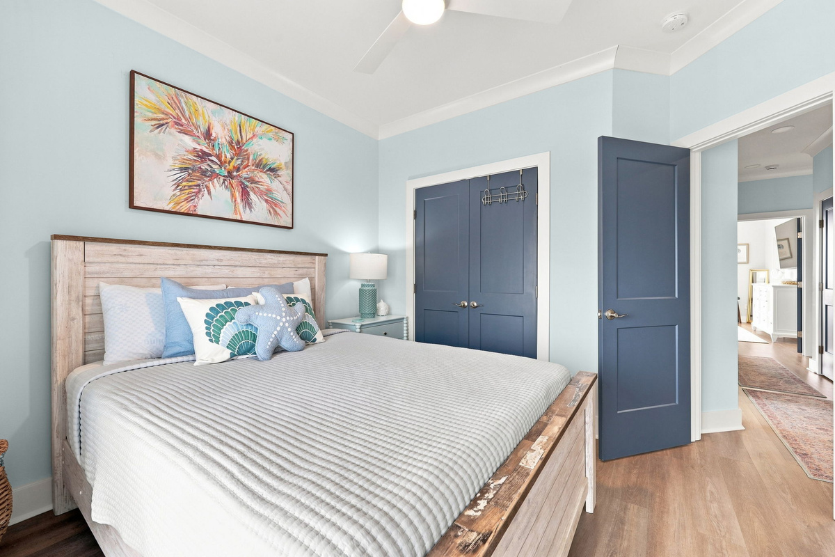 Inviting second-floor queen bedroom with a relaxing coastal color palette, spacious layout, and convenient access to the hallway and ensuite bathroom