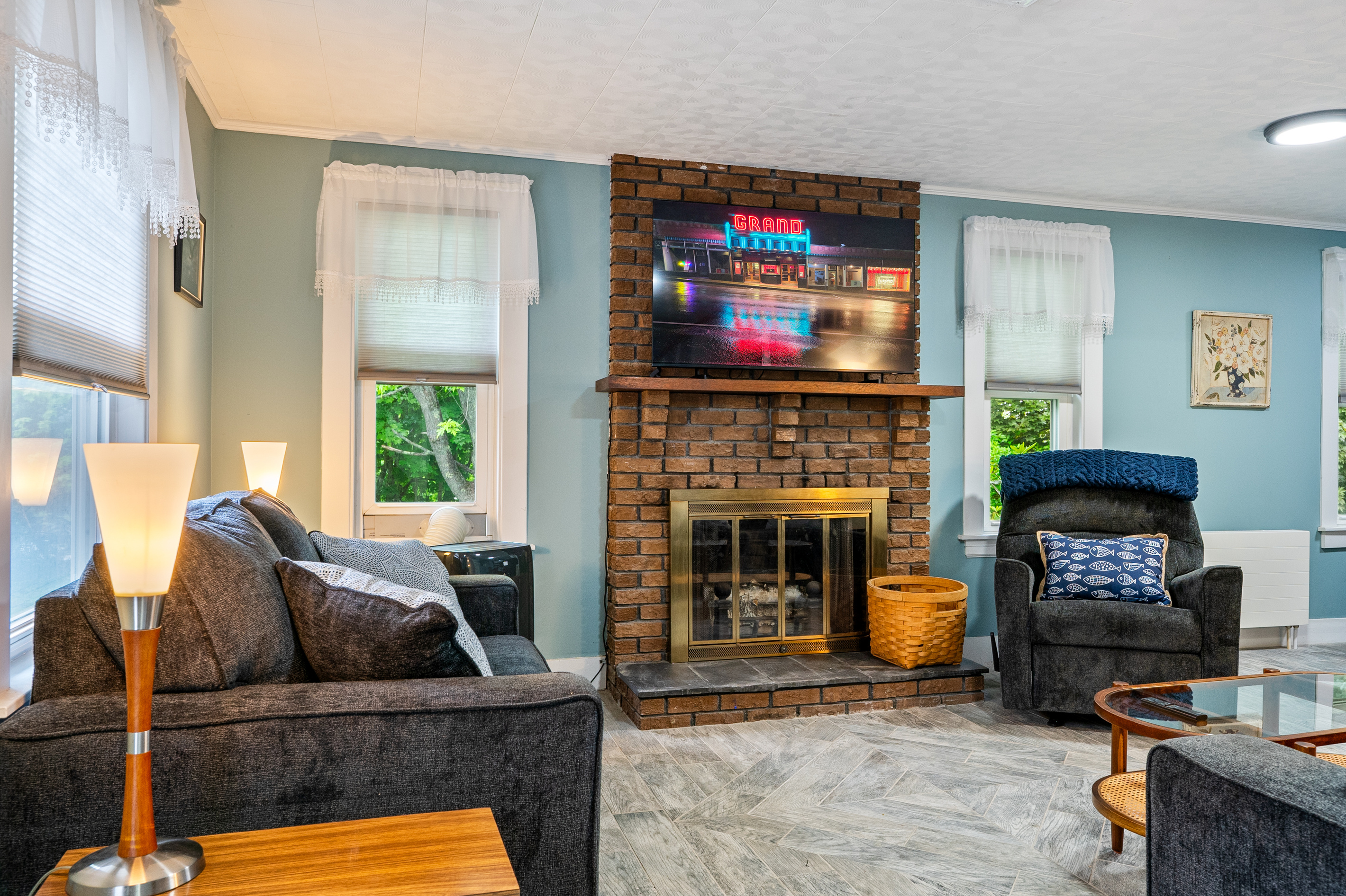 Enjoy a perfect view from any seat in the room. This layout connects our plush sofa and armchair directly to the central TV and decorative fireplace, creating an inviting, comfortable space for your group to unwind after exploring Maine.