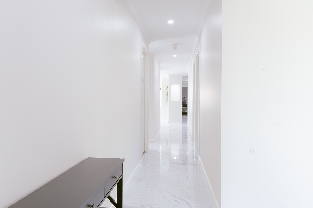 This hallway at Willows Stays Holiday gives the home a bright internal connection, with clean tiled floors leading through to the main living areas.