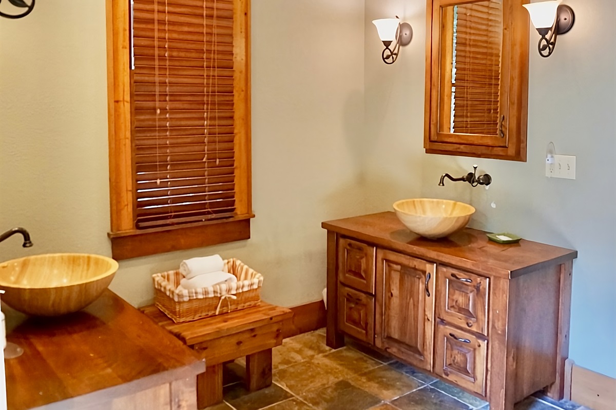 Warm wood tones and unique vessel sinks create a spa-like retreat.