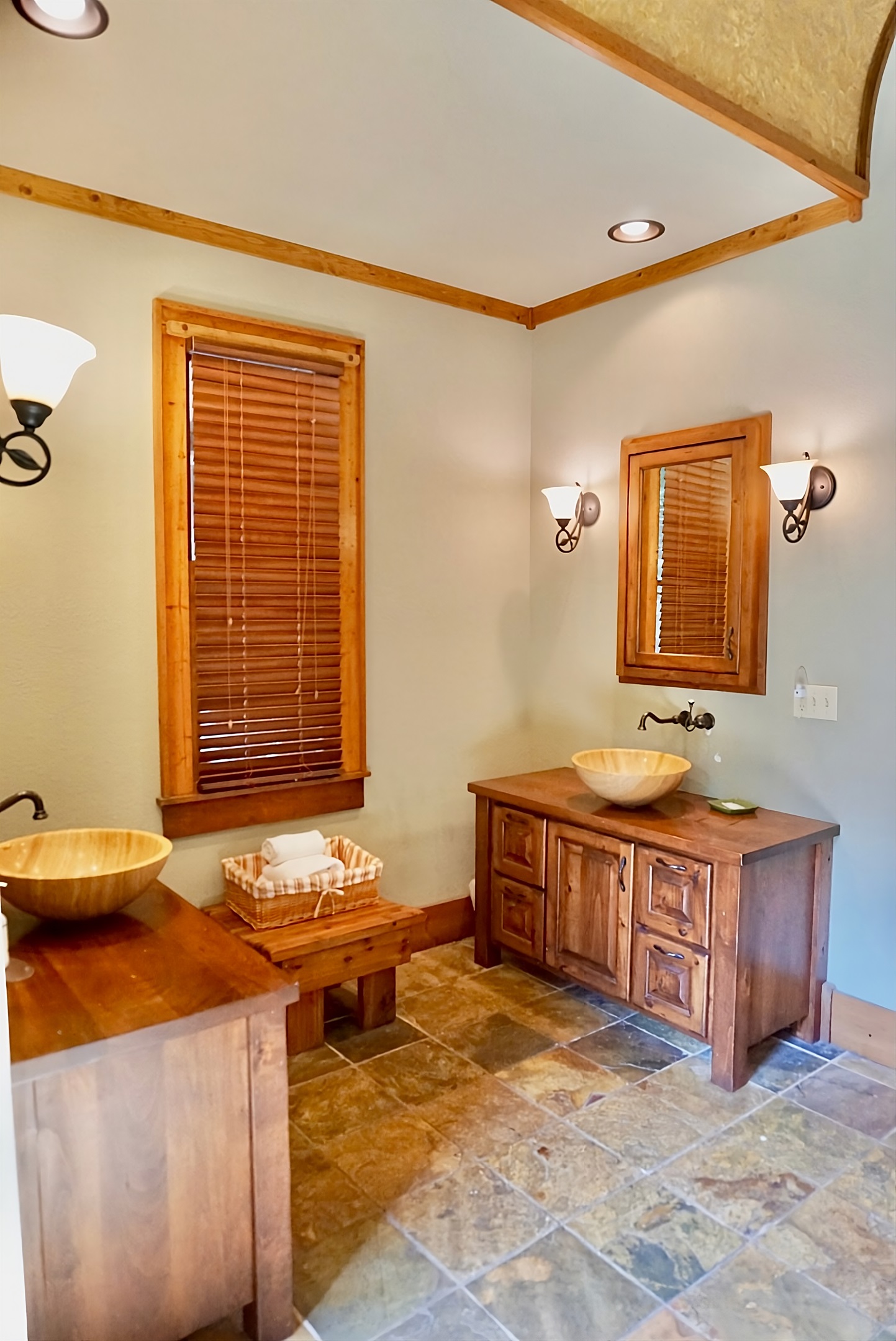 Warm wood tones and unique vessel sinks create a spa-like retreat.