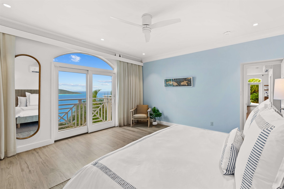 Primary suite with AC, king bed, en-suite bath, large windows, and ocean views. Ideal for privacy and relaxation.