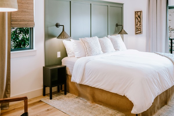 Premium Comphy linens at Rancher's Rest &mdash; a pillow-top king bed layered with soft modern Western styling, upstairs at Gaines Ranch on the Square.
