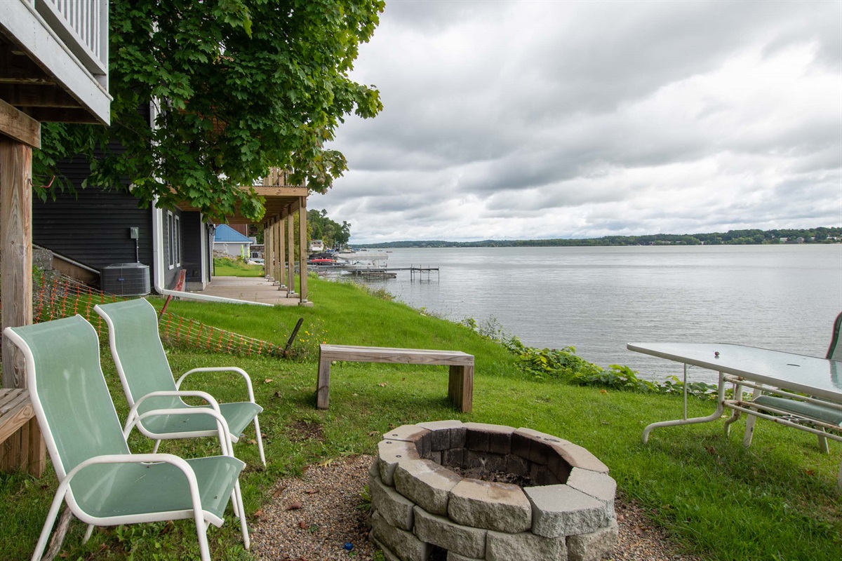 Grassy lakeside yard with chairs for front-row water views.