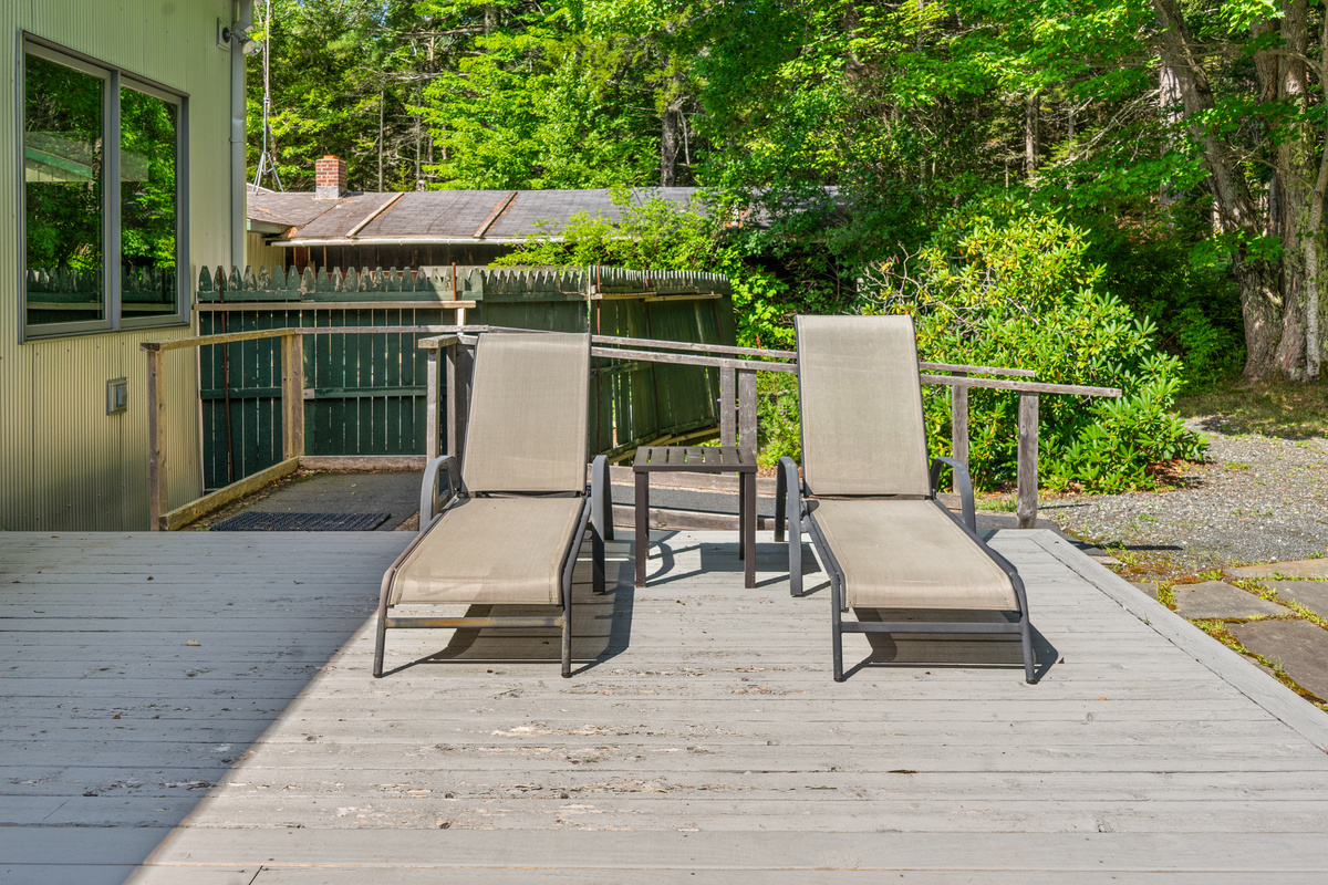 Relaxation meets accessibility at "The Crag." Enjoy dual sun loungers on the back deck, equipped with a step-free ramp and side path connecting seamlessly around the house for guests with mobility needs, all bordering Acadia.