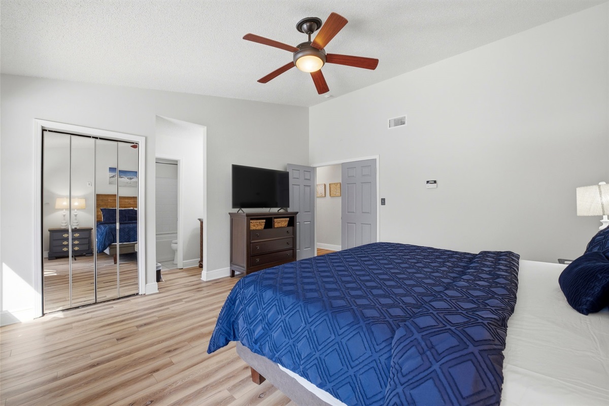 This well-appointed bedroom includes a king bed, dresser with TV, and mirrored closet doors that add both style and functionality. With easy access to the adjoining bathroom and plenty of room to relax, it’s the perfect private retreat after a day at the b