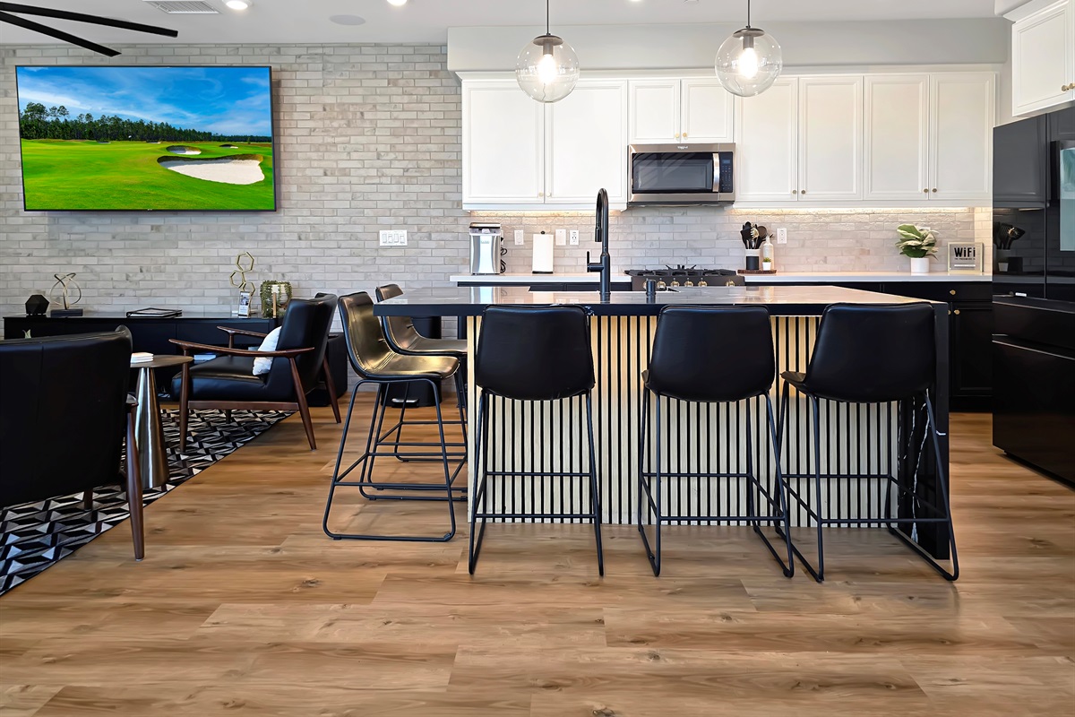 Updated kitchen with tuxedo cabinets, seating for five around the kitchen island.