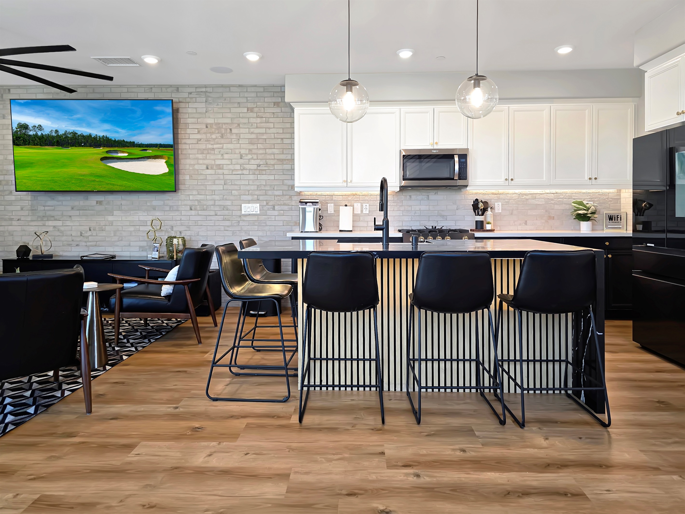 Updated kitchen with tuxedo cabinets, seating for five around the kitchen island.