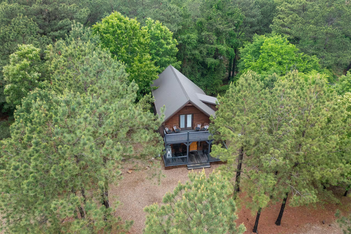 Exterior Retreat: Nestled among tall pines, enjoy a spacious deck for outdoor gatherings!