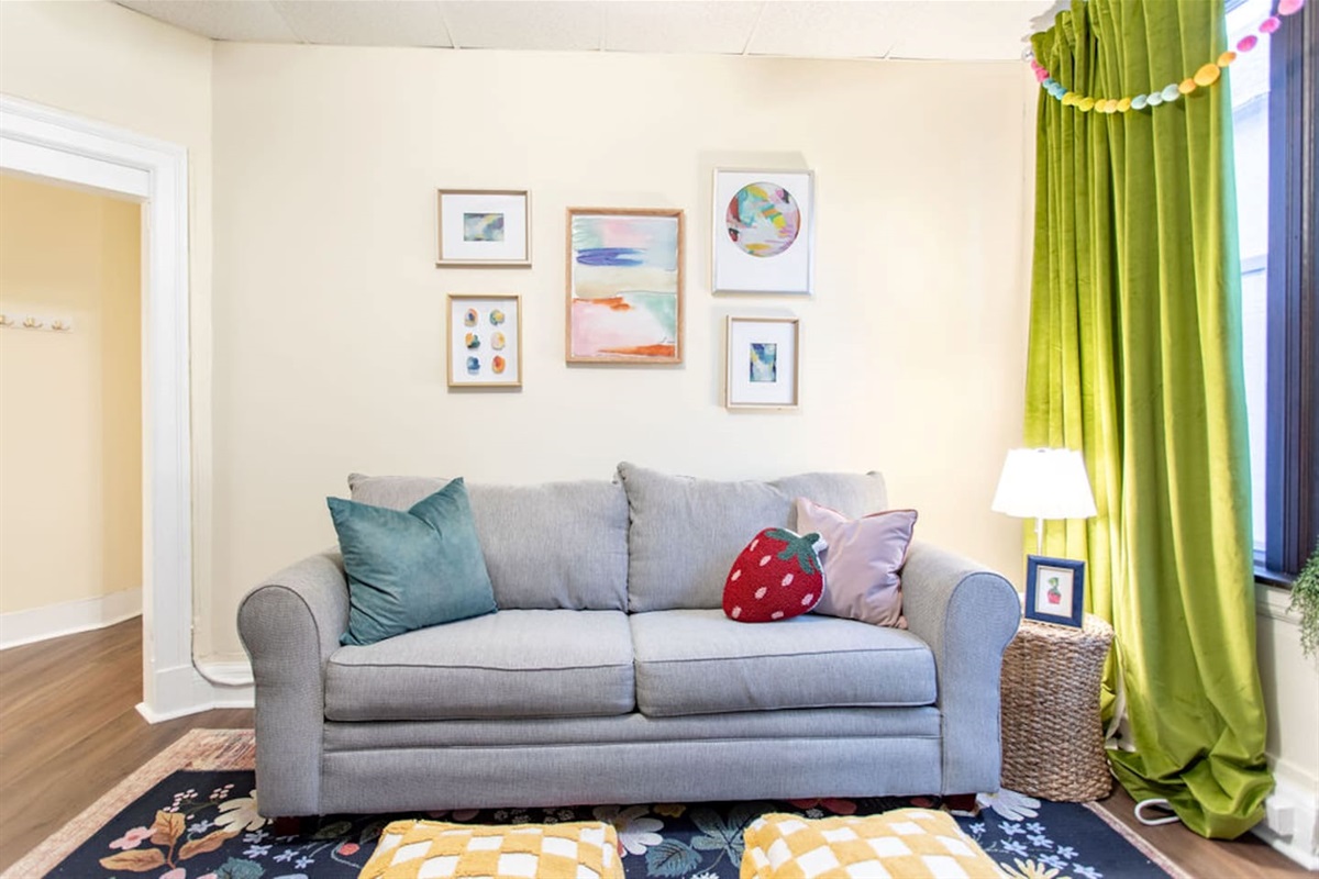 Bright and spacious living room featuring a comfortable sofa bed, perfect for relaxing or accommodating extra guests.