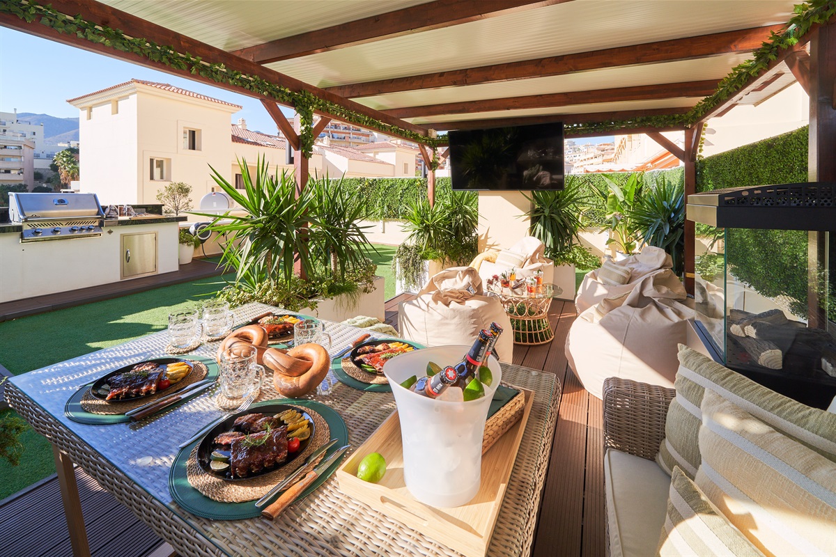 Relax beneath the covered pergola with cozy seating, fireplace, and dining area. Perfect for long evenings, romantic dinners, or movie nights on the outdoor TV under soft ambient lights.