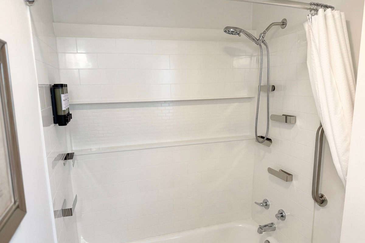 Combination tub and shower with an adjustable handheld showerhead.