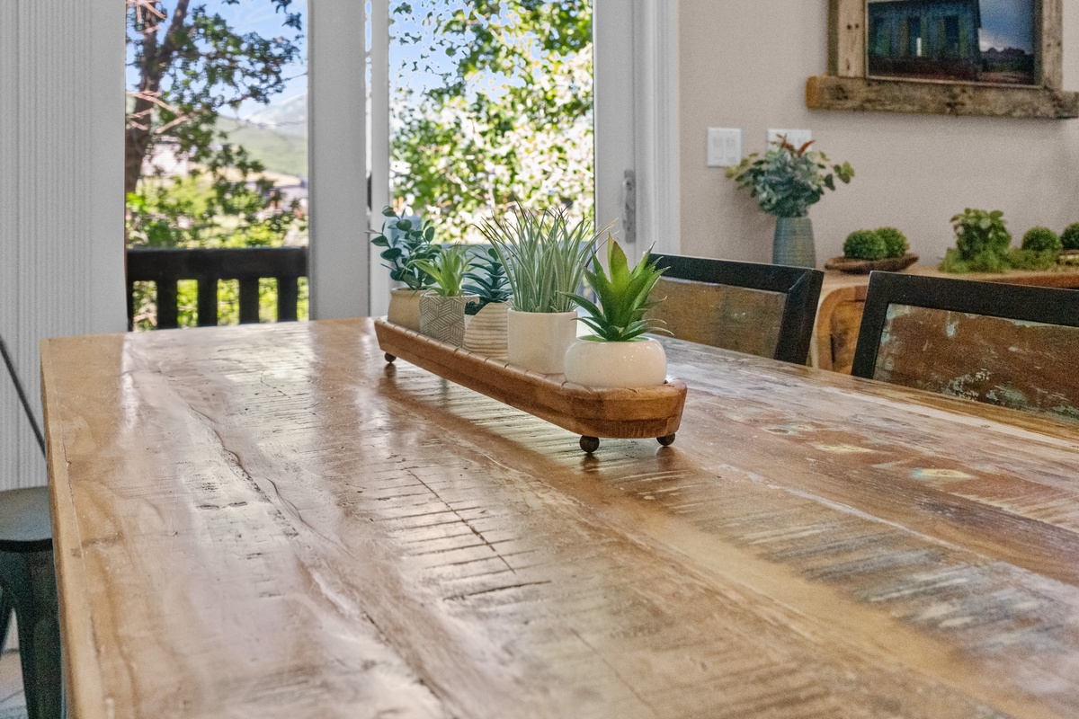 Gather around the beautiful rustic dining table for meals, games, and conversation, all surrounded by natural light and peaceful mountain-lake views.