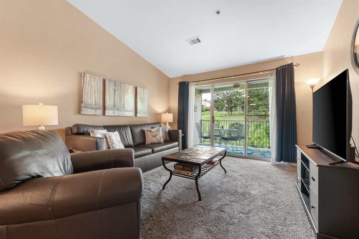 Vaulted ceilings, roomy seating, and deck access make the living room an easy place to settle in after a day in Branson.