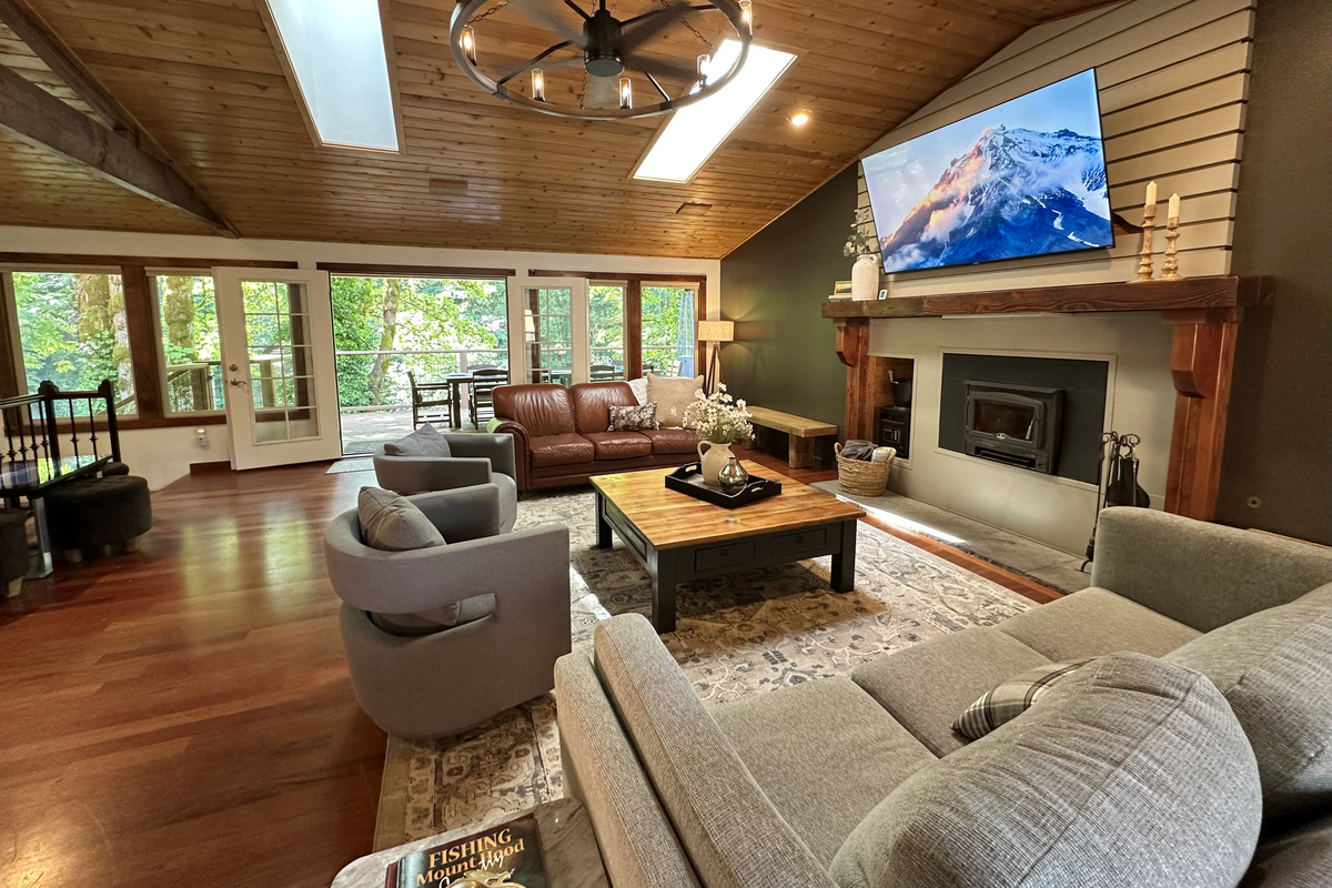 Natural light streams into the large gathering room with huge windows & skylights. Snuggle up for a movie, gather around the woodburning fireplace, listen to music on the record player, or play  the Infinite Game table... there's something for all!