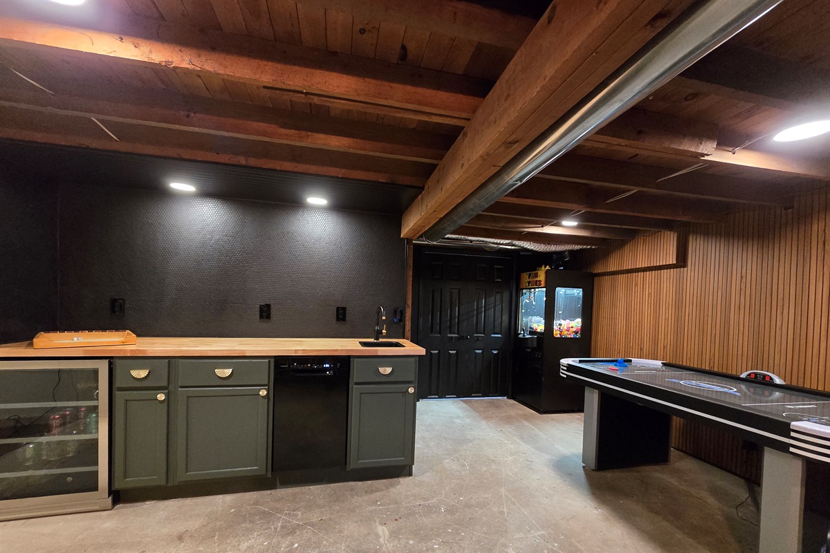 🎯 Entertainment Meets Style: This cozy game room features a sleek built-in bar with a beverage cooler, mini sink, and moody lighting—perfect for mixing drinks and making memories.
