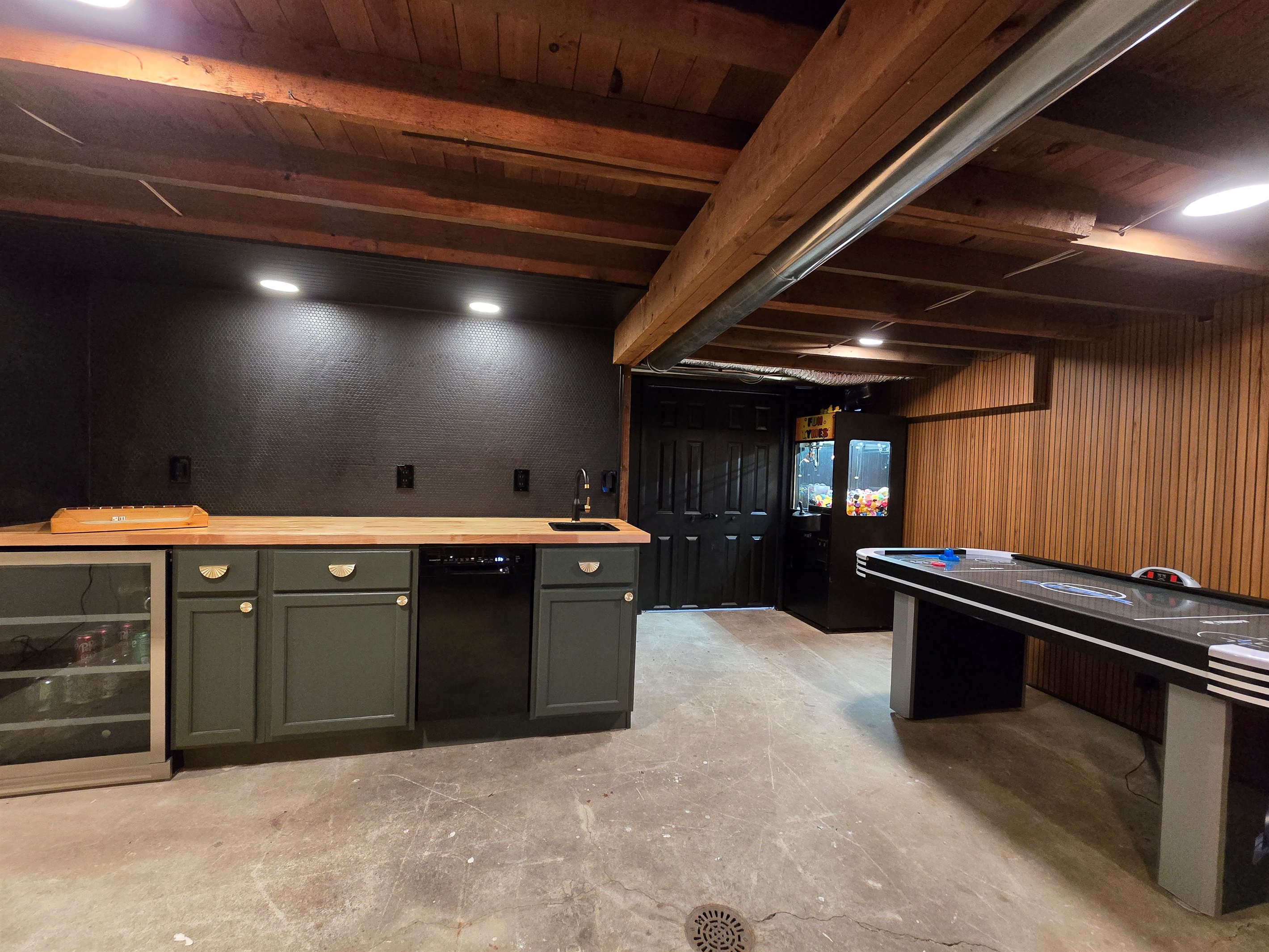 🎯 Entertainment Meets Style: This cozy game room features a sleek built-in bar with a beverage cooler, mini sink, and moody lighting—perfect for mixing drinks and making memories.