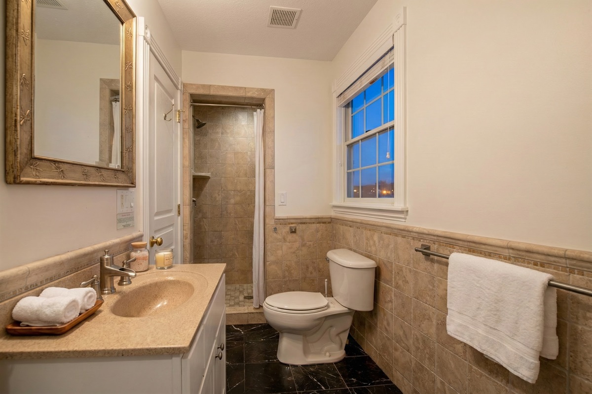 Unwind and relax in The Hemingway's exquisite bathroom! Lose yourself in an luxurious space designed to help you achieve a sense of peace and tranquility. Soak in the rain shower and admire th
