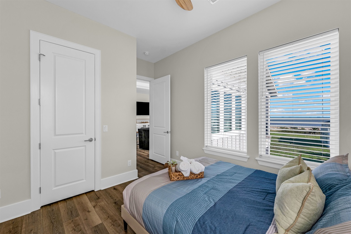 Costa Cristal Bedroom 2: Cozy queen bed with large windows, natural light, and relaxing views. Perfect for a restful night’s sleep.