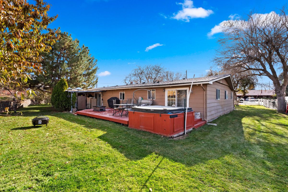 Hot tub on the back patio with seating for up to 8 guests.