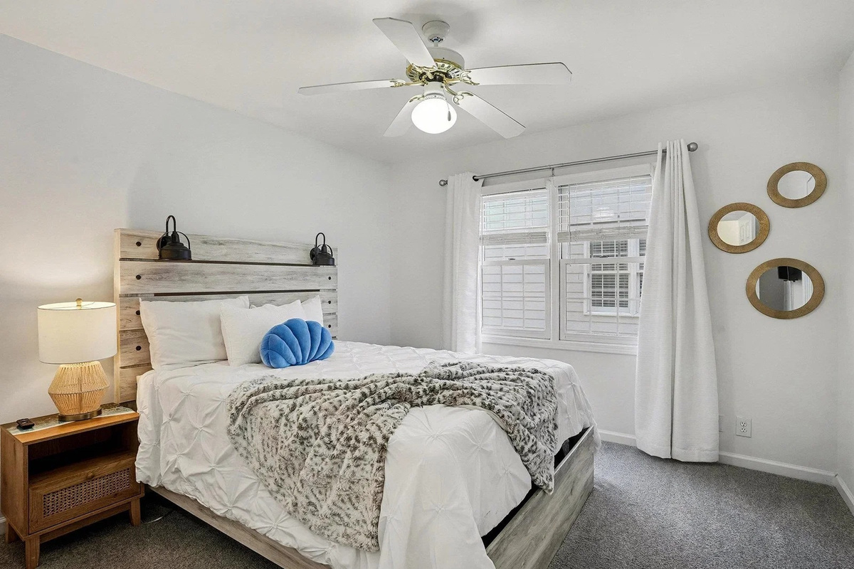 Upstairs queen bedroom with ceiling fan and soft coastal linens