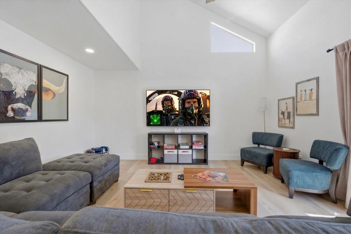 Large living room has an extra large sectional, individual chairs, big screen smart TV, board games, two different areas to charge your devices.