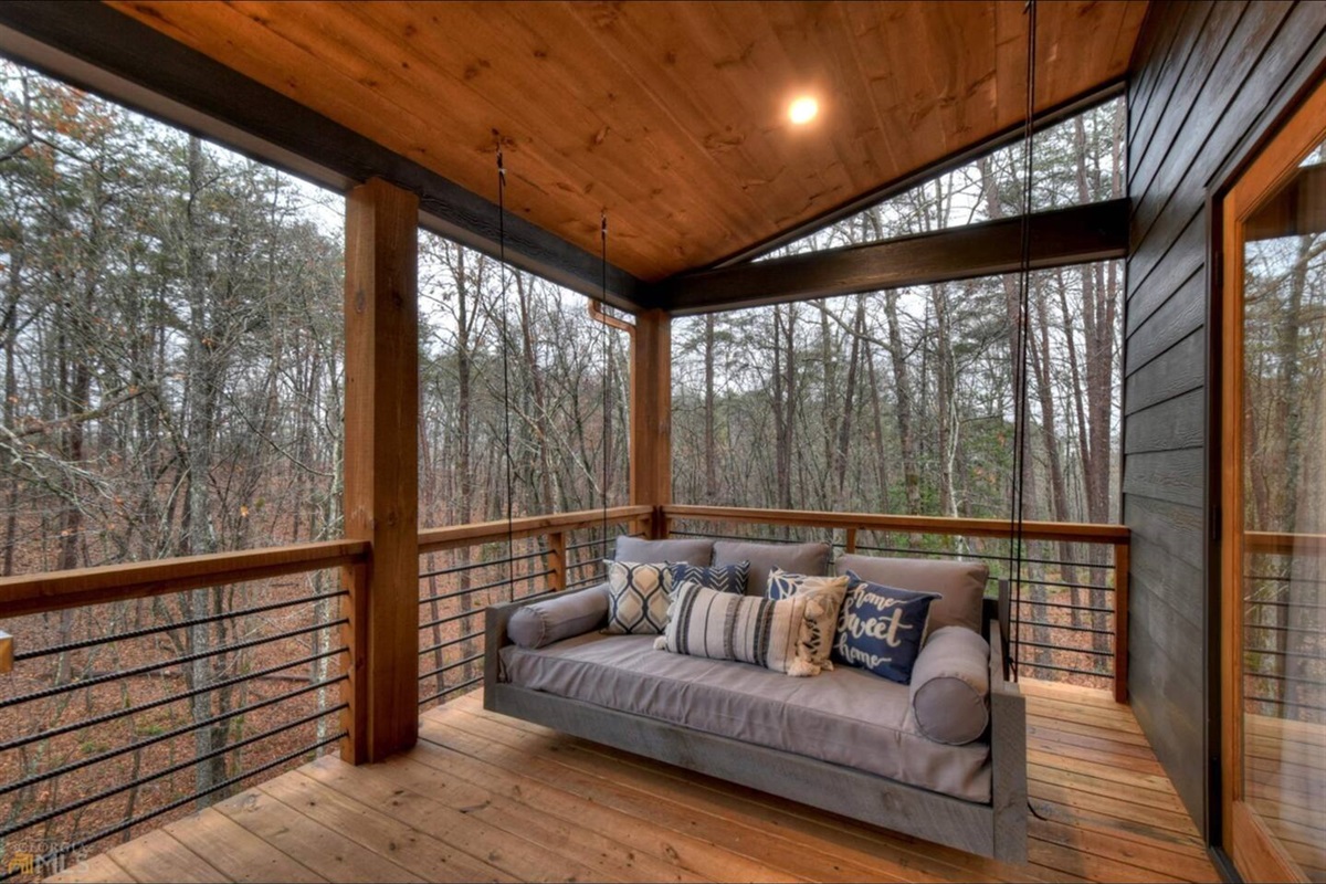 Twin bed sized porch swing with plenty of pillows. On the top deck that shares the gas grill, dining table, and outdoor fireplace and seating area.