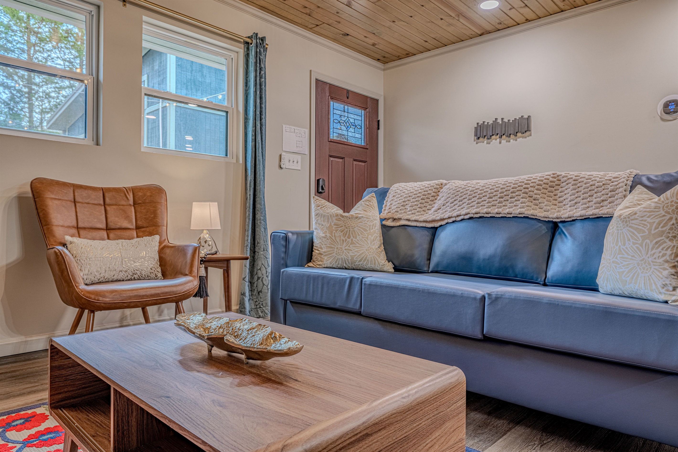 This inviting seating area combines warm wood ceilings with modern furniture for a cozy, sophisticated mountain vibe.