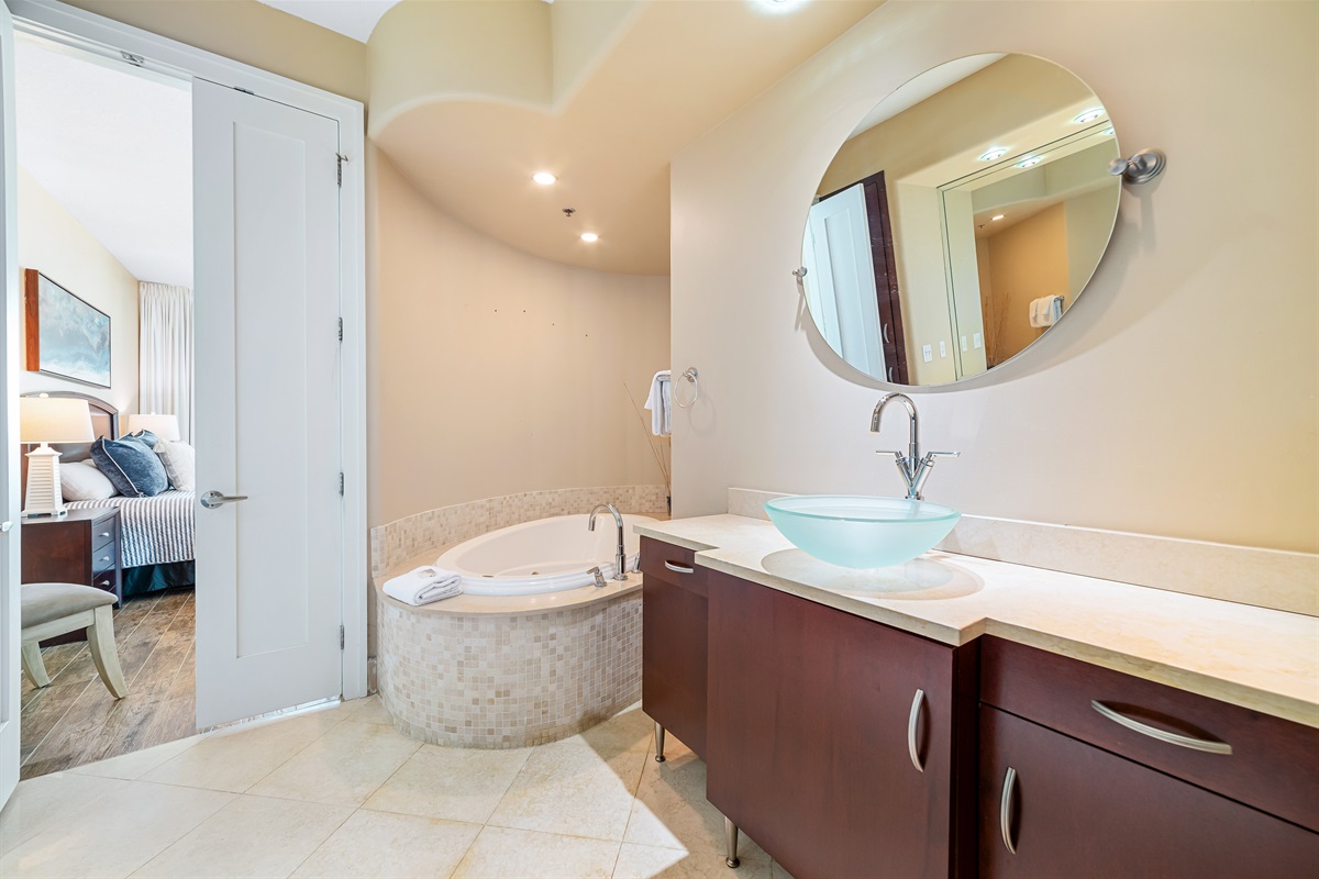 Indulge in the seamless flow between the luxurious primary bathroom and bedroom. Featuring a spa-like soaking tub, elegant vanity with a glass vessel sink, and serene ambiance, this space offers a private retreat.