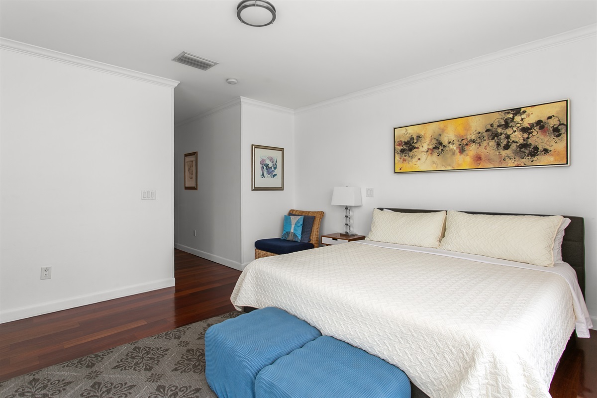 Very private corner Primary Suite with desk, walk-in closet, en-suite bath, and a balcony with city and waterway views