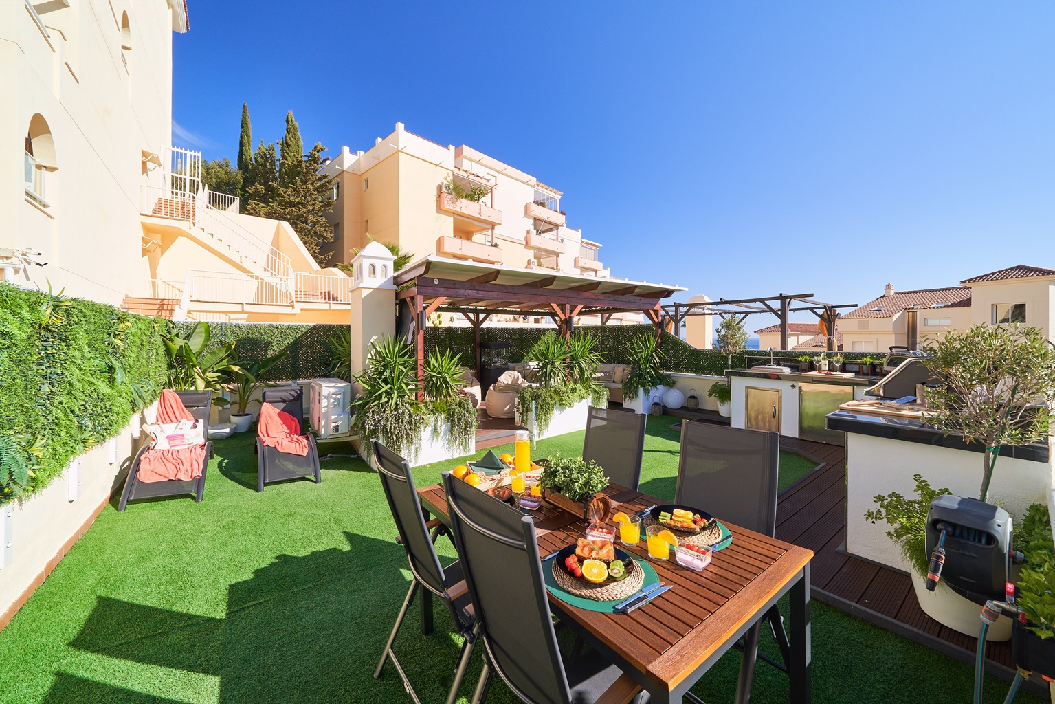 Cook with a view in the fully equipped outdoor kitchen featuring a BBQ, pizza oven, fridge, and sink. Dine al fresco under the open sky surrounded by soft lighting and fresh sea breeze.