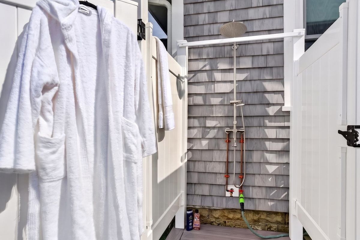 Convenient outdoor shower area with fresh bathrobes ready for your stay.