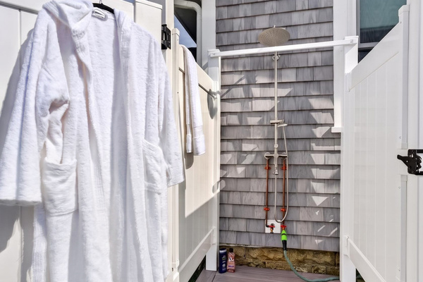 Convenient outdoor shower area with fresh bathrobes ready for your stay.