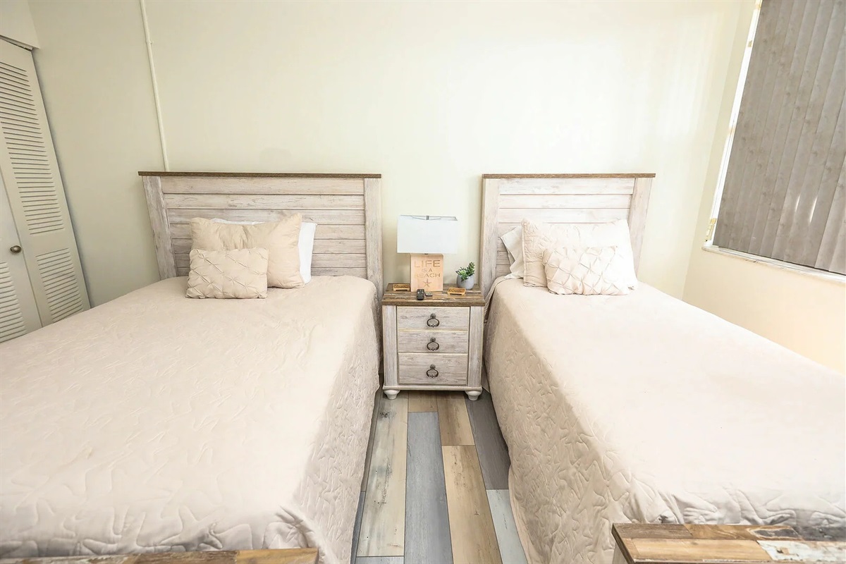 Twin bedroom with comfortable bedding and a clean coastal feel.