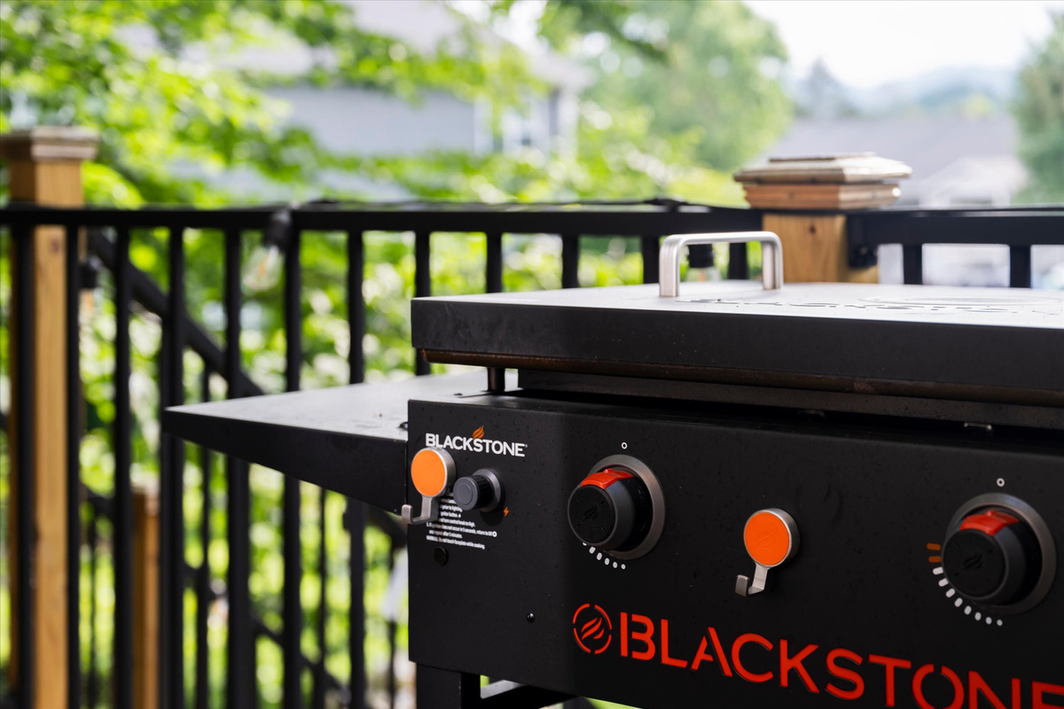 Deck with Blackstone Grill, cafe lights, bistro table and sitting chairs