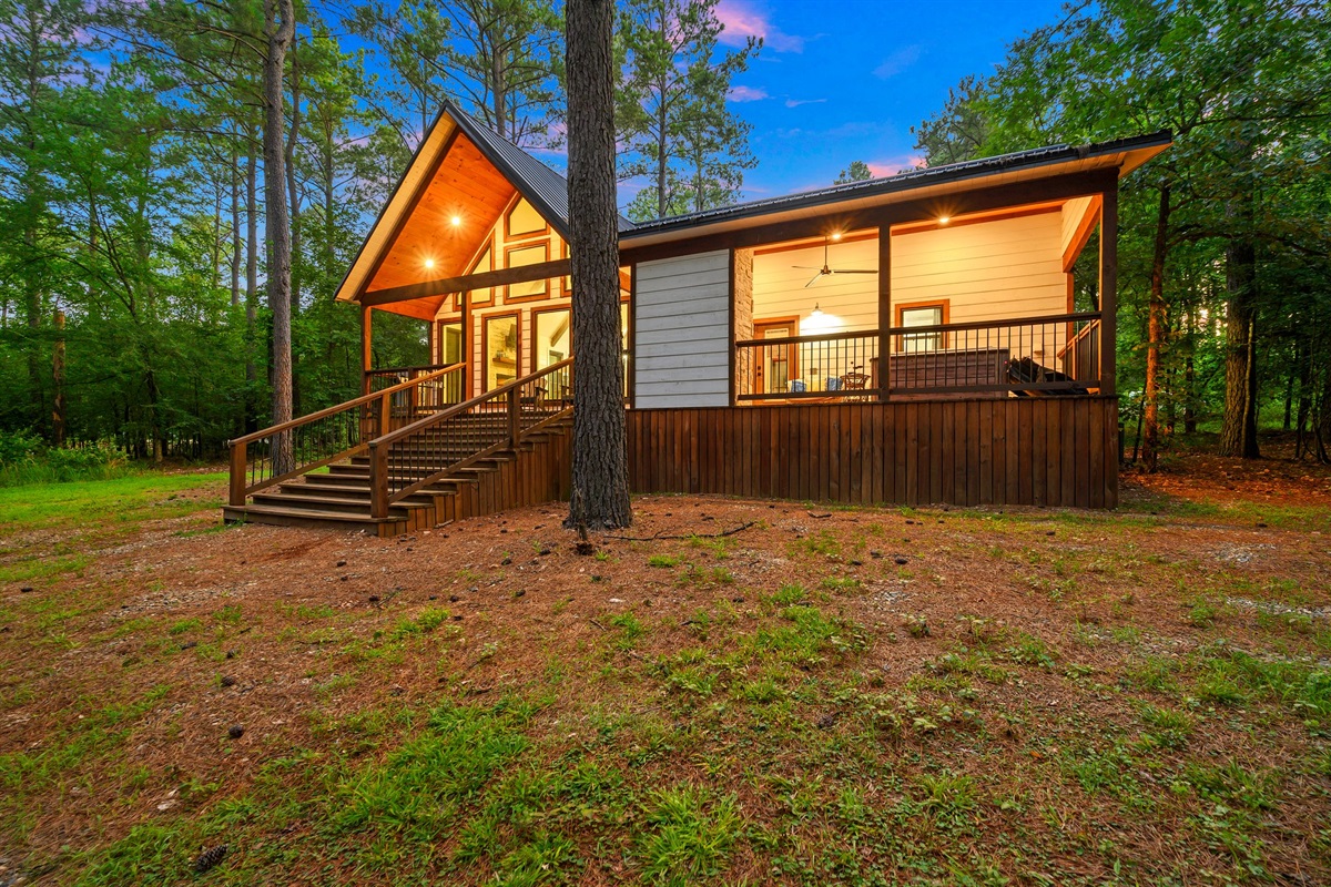 Charming Cabin Exterior: Relax on the porch and soak in the serene wooded views!