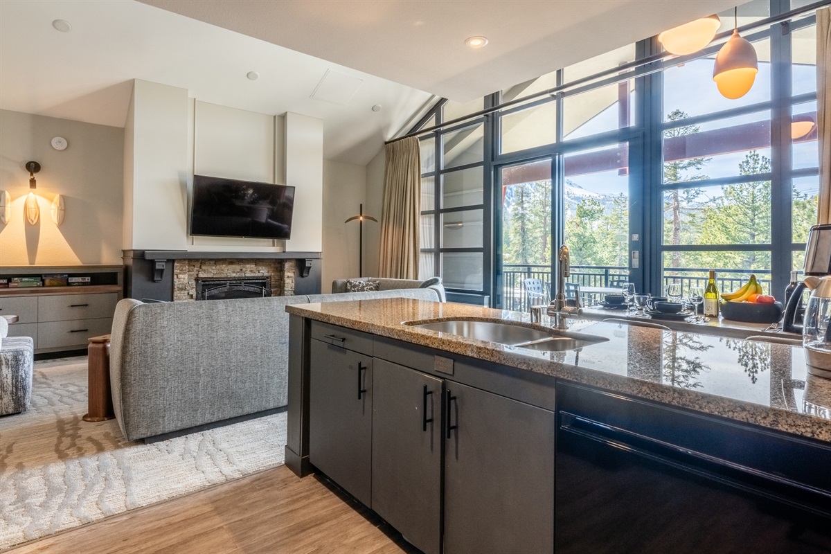An unusually spacious, open layout with soaring ceilings brings the living, dining, and full kitchen together—creating a light-filled space that feels expansive, effortless, and quietly memorable from the moment you walk in.