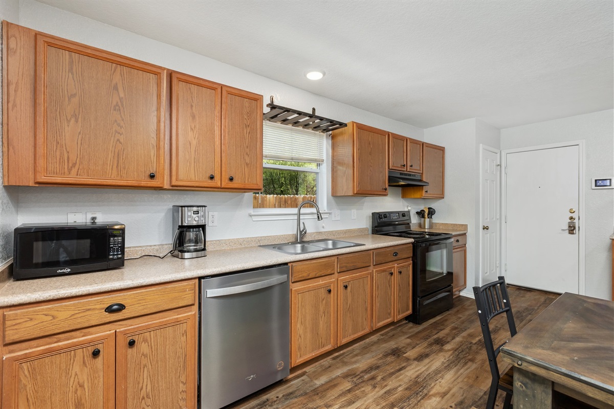 Kitchen with stainless appliances, microwave, dishwasher, refrigerator, and generous wood cabinetry. Plenty of storage for groceries and cookware — ideal for extended stays near Randolph AFB and Fort Sam Houston.