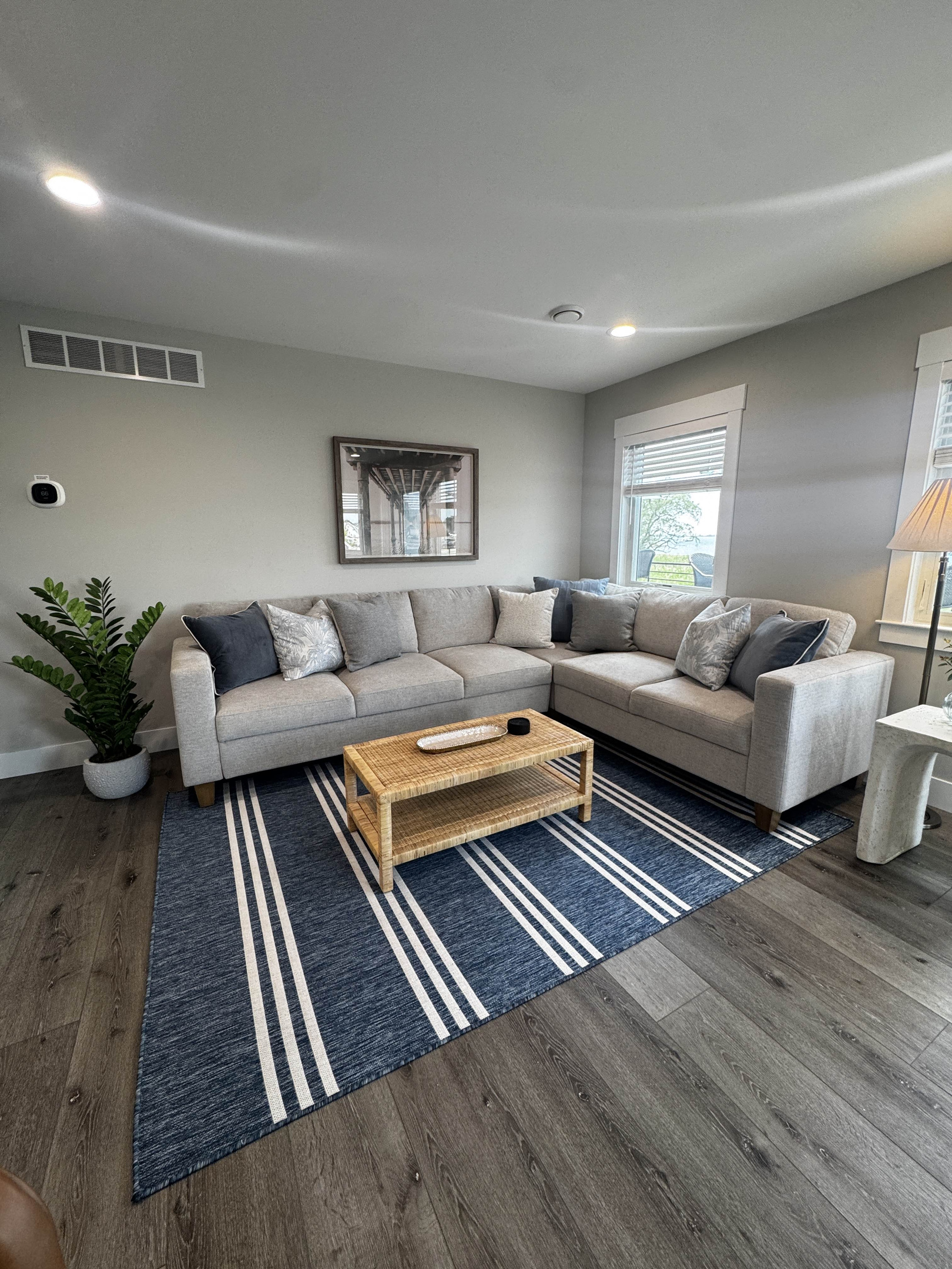 Bright and comfortable living room with a spacious sectional sofa, natural light, and a cozy coffee table setup—perfect for relaxing and spending time indoors.