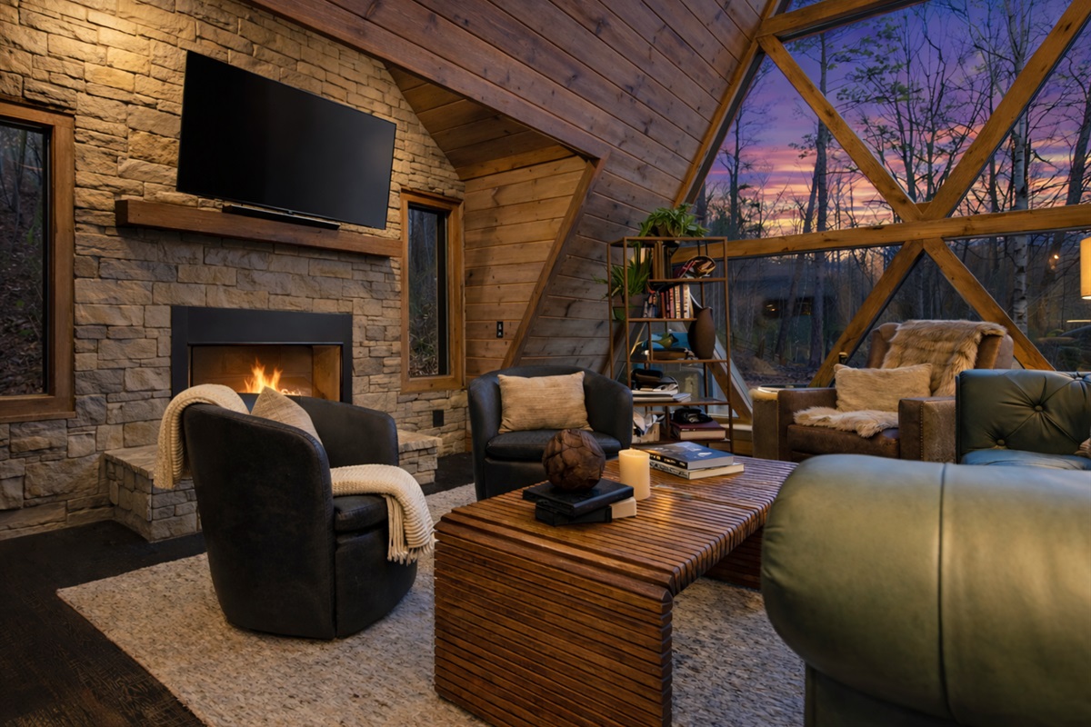 Thoughtfully designed A-frame living with vaulted wood ceilings, a stone fireplace, and expansive glass bringing the outdoors in.
