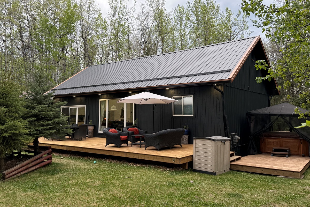Brand-new 12x44’ front deck with cozy outdoor seating and peaceful forest surroundings.