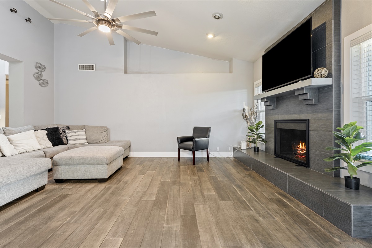 This stylish living room offers plush seating, a large smart TV, and fireplace ambiance designed for total relaxation and quality time.