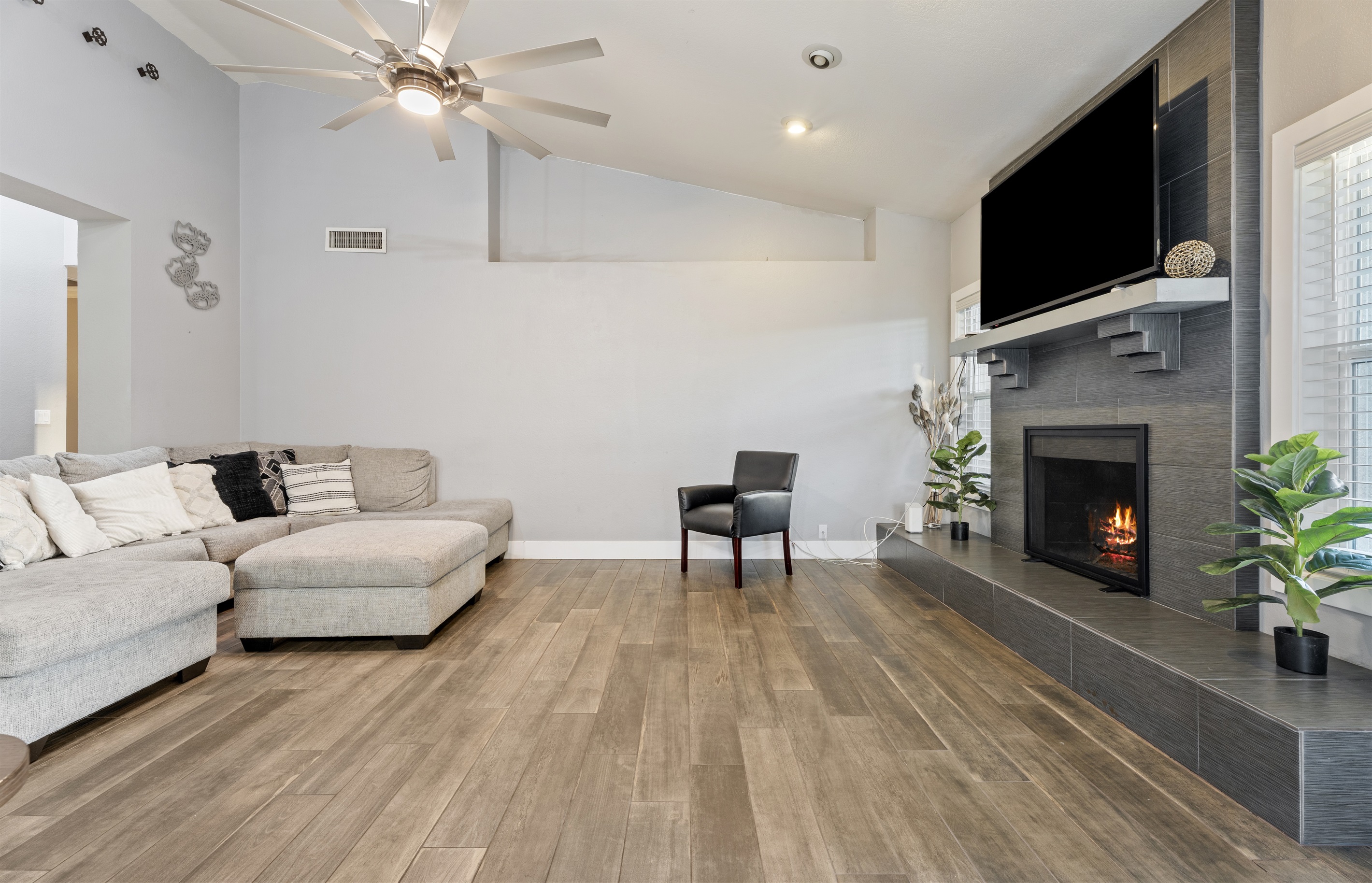 This stylish living room offers plush seating, a large smart TV, and fireplace ambiance designed for total relaxation and quality time.