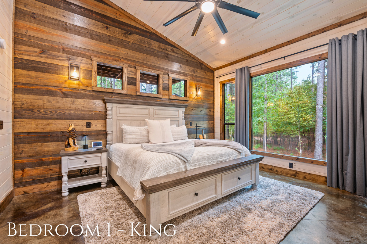 Relax in this cozy king bedroom with charming rustic decor and peaceful views right outside the window.