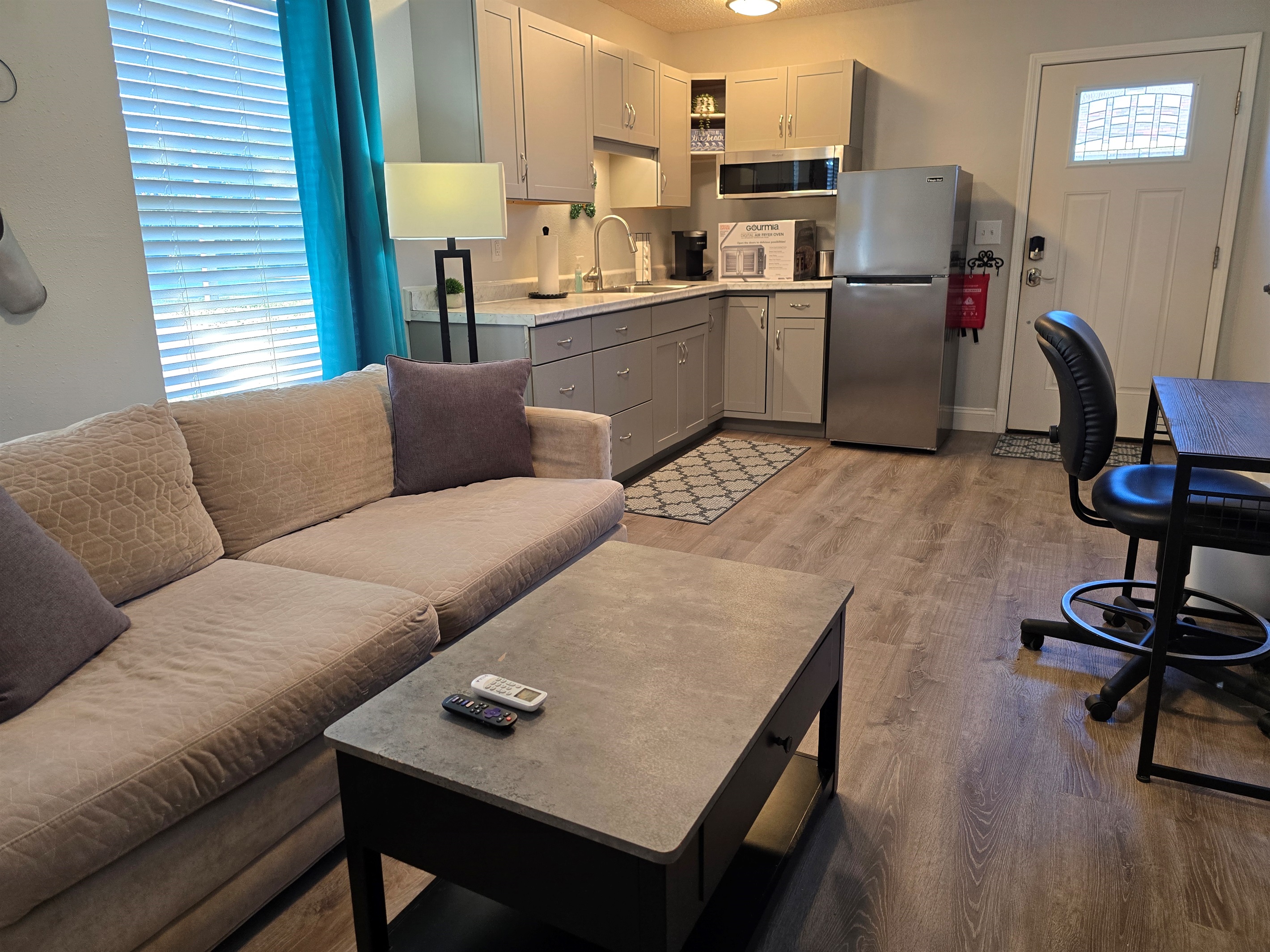 Enter through the kitchenette where you'll find dishes, pans, silverware, a double cook top, a counter air fryer, Keurig, toaster & full sized fridge.  For supplies, you'll find some starter Keurig pods, a filtered water pitcher, and ice cube trays & soap.