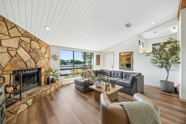 Open living room with fireplace and panoramic lake views.