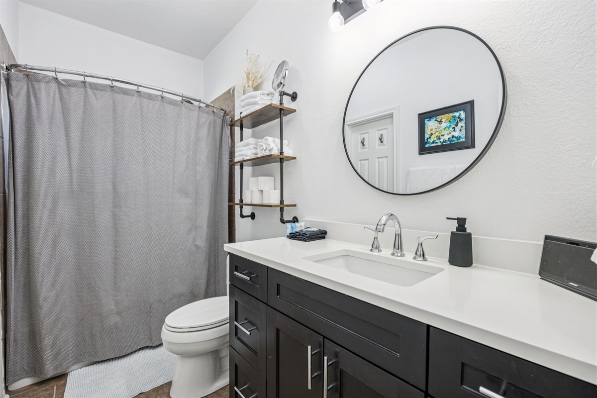 Bright and functional shared bathroom with modern fixtures and plenty of space for guests.