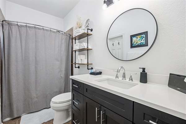 Bright and functional shared bathroom with modern fixtures and plenty of space for guests.