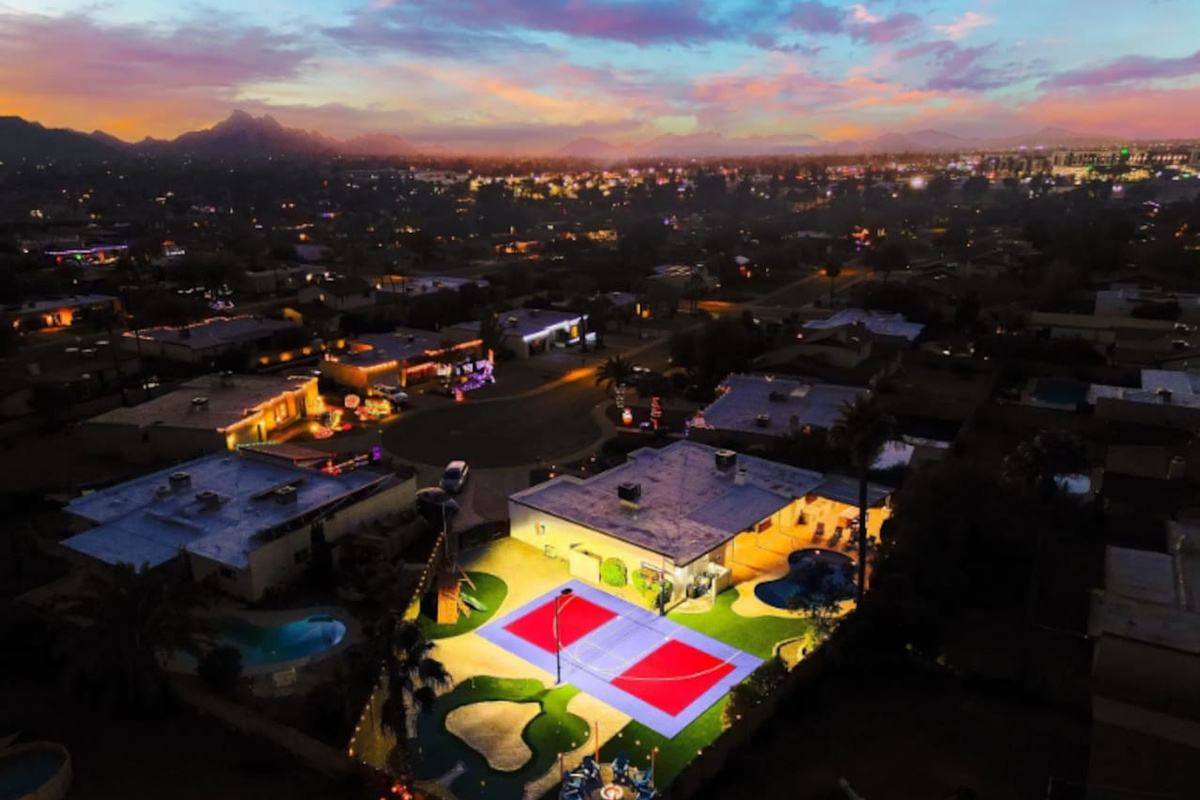 Pool, court, and putting green all visible in one frame — the kind of layout that lets everyone do their own thing at once.