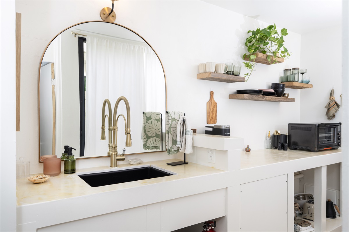 A minimalist kitchenette that makes the most of its space, featuring all the essentials for light meals and coffee breaks.